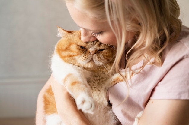 かわいい猫にキスする若い女性をクローズアップ