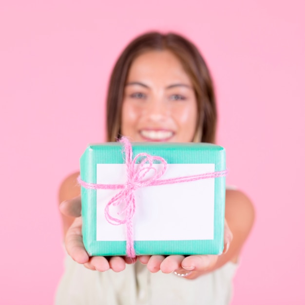 Primo piano del contenitore di regalo d'offerta della giovane donna legato con corda rosa