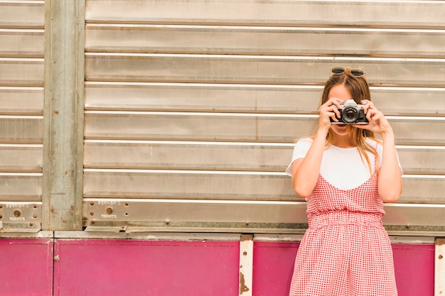 Close-up of young woman photographing with camera