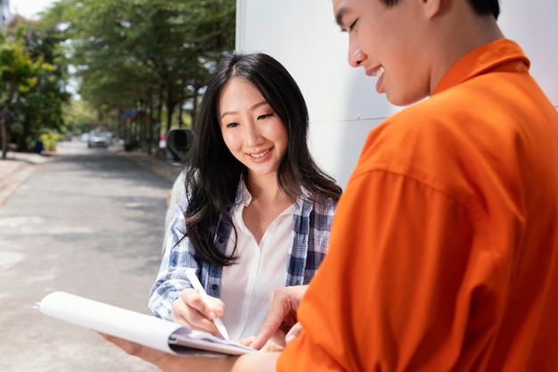 Close up on young woman signing for package delivery