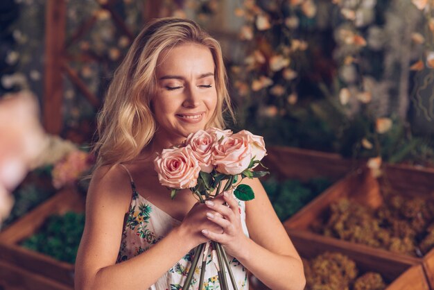 Close-up of young woman smelling the pink roses