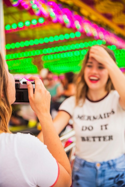 彼女の友人の写真を撮っている若い女性のクローズアップ