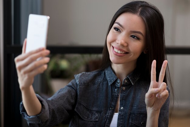 Close-up young woman taking a selfie with her phone