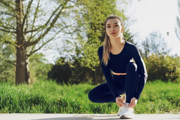 Foto gratuita primo piano di una giovane donna che allaccia i lacci sulle sue scarpe sportive