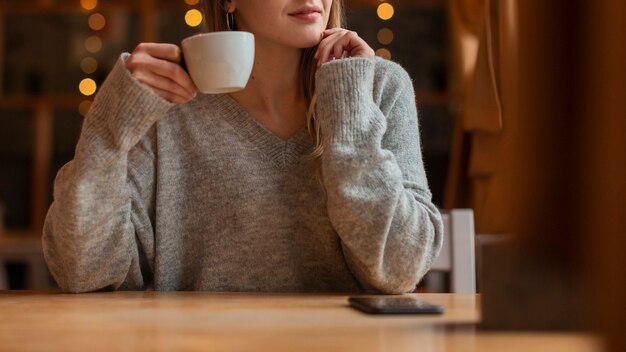 コーヒーとクローズアップの若い女性