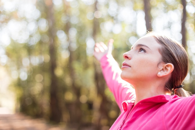 Free photo close-up of young woman with open arms outdoors