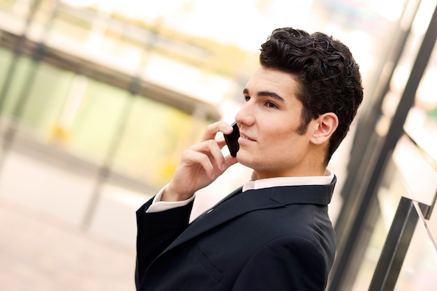 Крупным планом молодого работника говорить на сотовый телефон