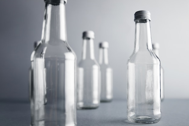 Close view on clear unlabeled empty glass bottles for cold beverages and drinks