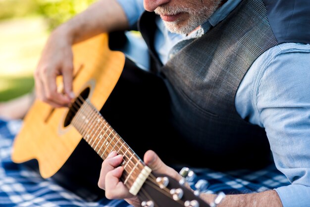 Близкий взгляд сконцентрированный человек играя гитару
