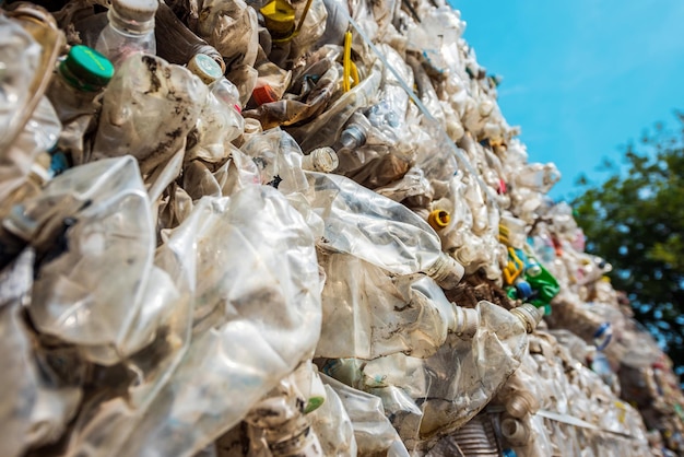 Foto gratuita vista ravvicinata di un cubo di immondizia di plastica compressa vicino alla fabbrica di riciclaggio dei rifiuti all'aria aperta