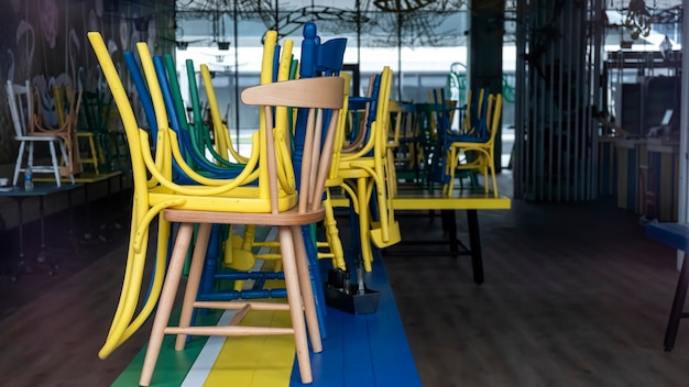 Closed cafe with raised multicolored chairs visible through the glass facade in Bucharest, Romania