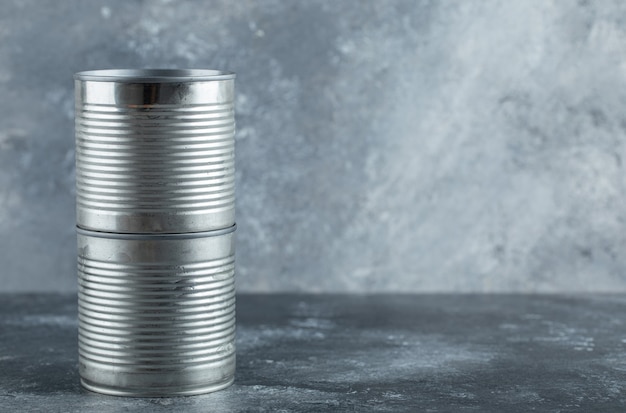 Closed tin cans placed on marble.