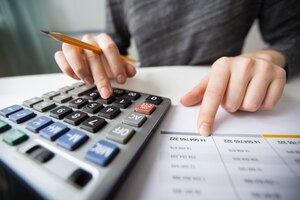 Primo piano del contabile mani conteggio sulla calcolatrice