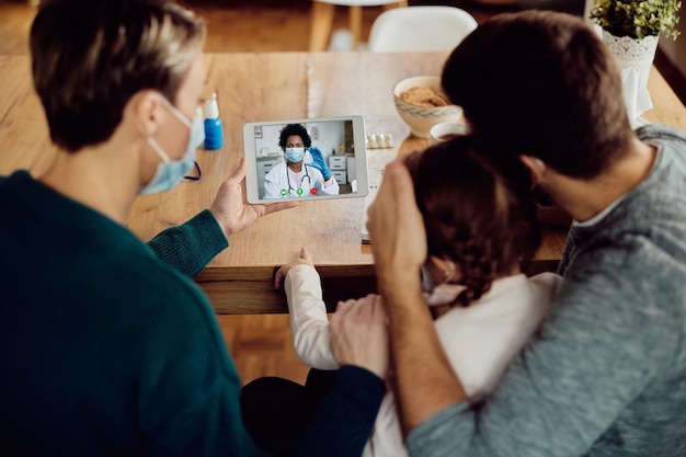 Foto gratuita primo piano di un medico afroamericano che ha consultazioni video con una famiglia a causa della pandemia di covid19