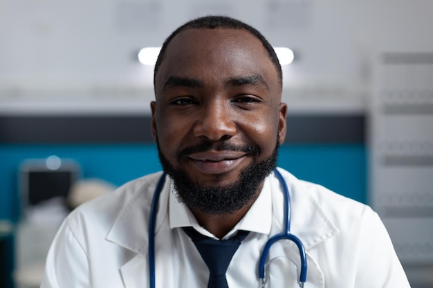 Closeup of african american specialist doctor with stethoscope working at medical treatment in hospital office. Practitioner man analyzing pharmaceutical prescription report. Healthcare service