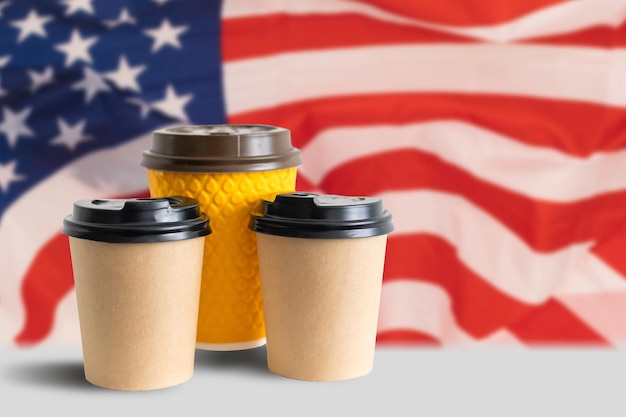 Closeup of American flag with coffee paper cup. Mockup of coffee paper cup