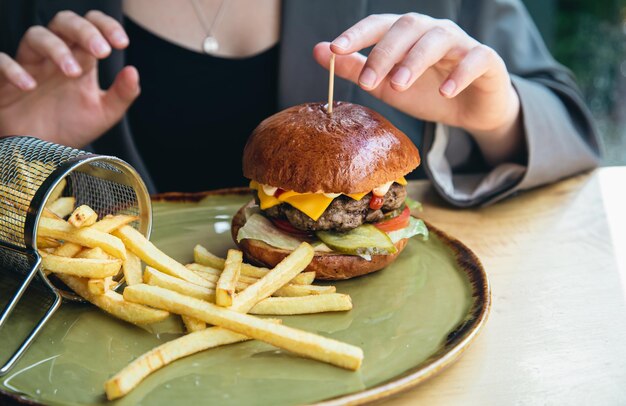 カフェでのクローズアップの食欲をそそるハンバーガーとフライドポテト