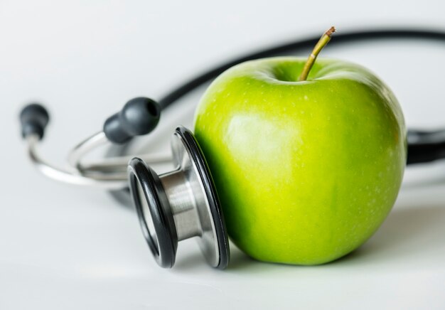 Макрофотография концепции яблока и стетоскопа здоровой пищи и здоровья