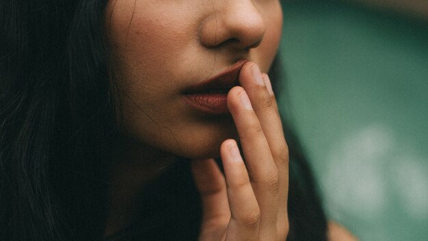 Closeup of an attractive woman with her fingers on her lips