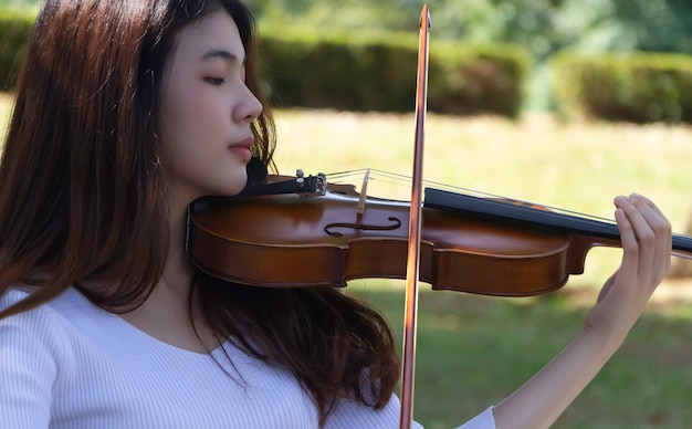 クローズアップ美しい女性が興味を持ってバイオリンを弾く モデルのポーズの肖像画 周りのぼやけた光 プレミアム写真 クローズアップ美しい女性が興味を持ってバイオリンを弾く モデルのポーズの肖像画 周りのぼやけた光 プレミアム写真