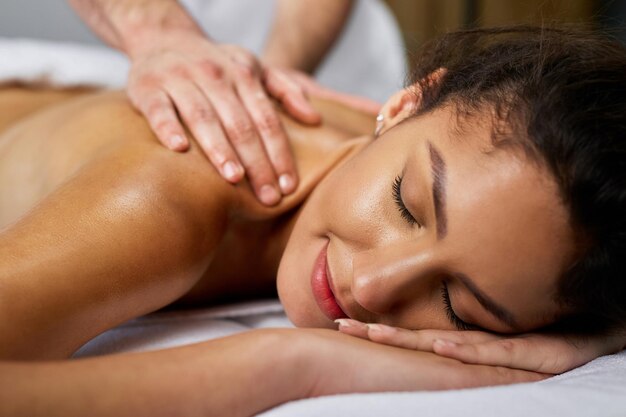 Closeup of beautiful woman having back massage at health spa