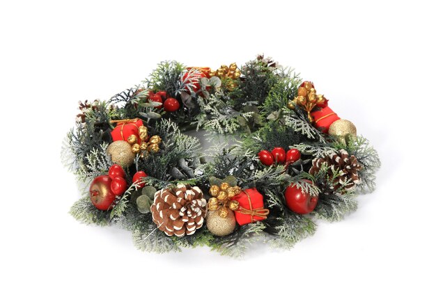 Closeup of a beautifully decorated wreath with pine cones, tiny presents on a white background