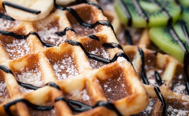 closeup belgian waffles with fruits covered with chocolate