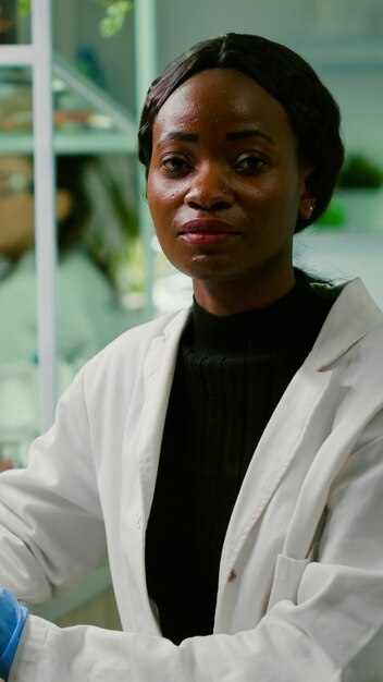 Closeup of biologist woman looking into camera while working in biological agronomy laboratory