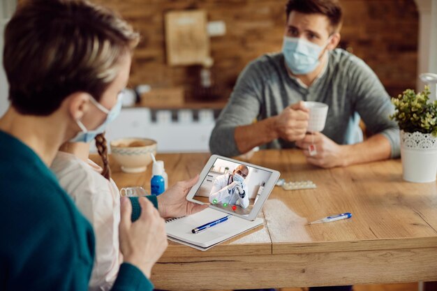 Closeup of black doctor having video call with a family during coronavirus pandemic