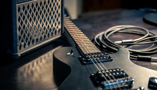 Closeup black electric guitar on a dark background