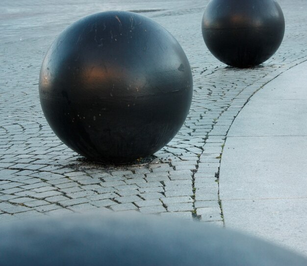 石の地面に黒い丸いボールのクローズアップ