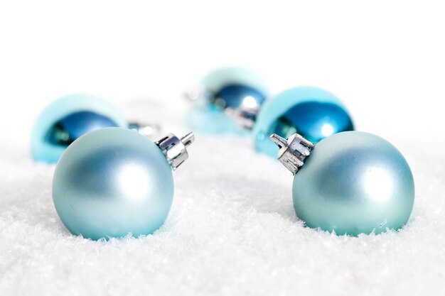 Closeup of blue Christmas bulbs on the snow