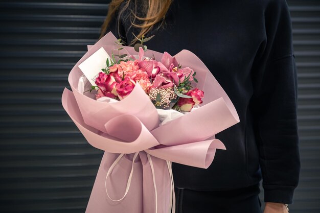 Closeup of a bouquet of pink flowers in female hands