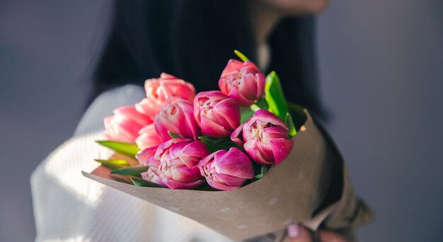 Closeup a bouquet of pink tulips in female hands