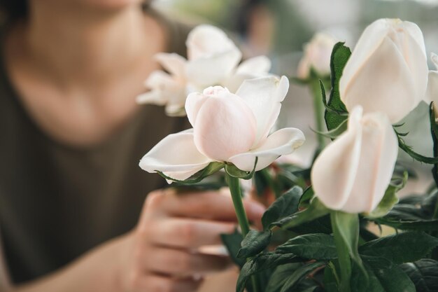 女性の花屋の手の中のバラの花束をクローズ アップ