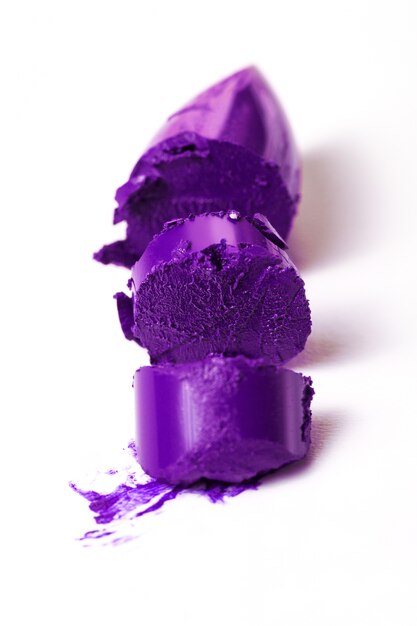 Макрофотография сломанной красивой фиолетовой помады. Мода. Яркий фон.