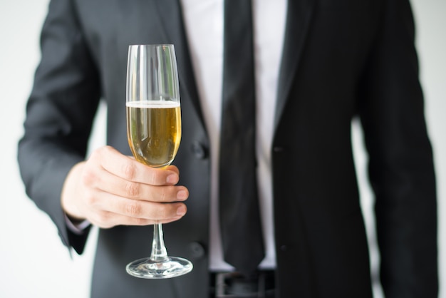 Primo piano del calice della holding dell'uomo di affari con champagne