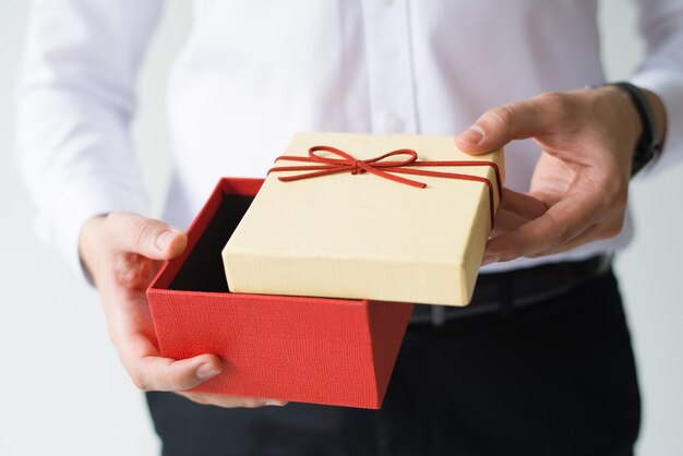 Крупным планом деловой человек, открытие подарочной коробке