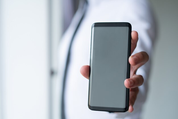 Closeup of business man showing empty smartphone screen