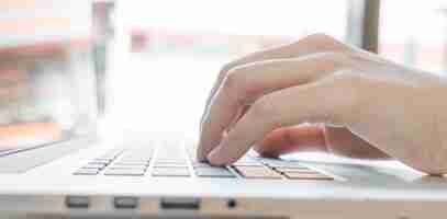 Free photo closeup of business woman hand typing on laptop keyboard
