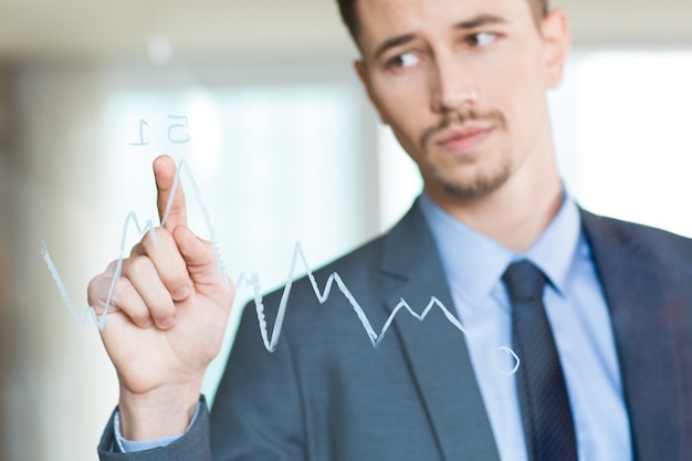 Free photo closeup of businessman pointing to graph on glass