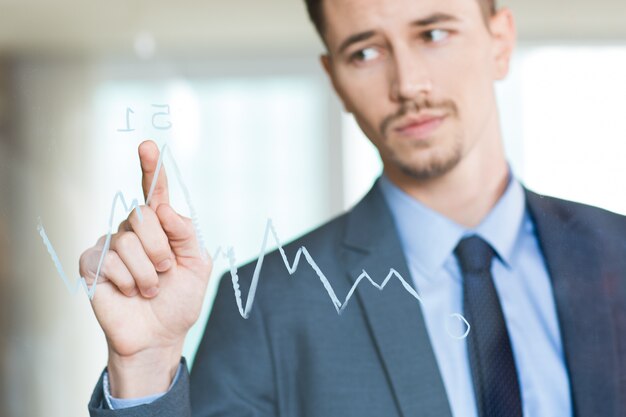Closeup of Businessman Pointing to Graph on Glass
