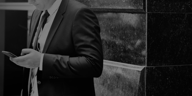 Макрофотография бизнесмен с помощью мобильного телефона серый масштаб