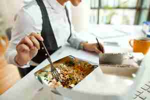Free photo closeup of businesswoman having a healthy meal while working in the office