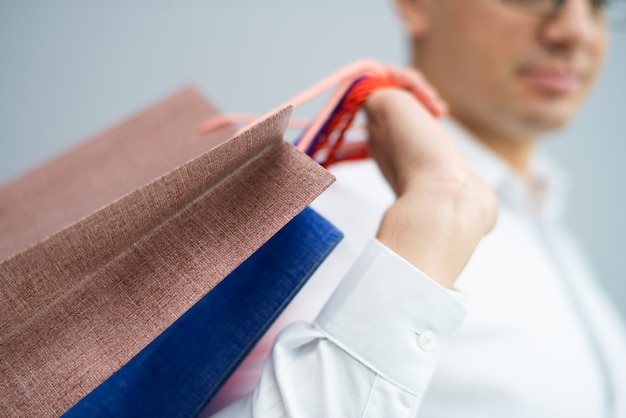 Free photo closeup of buyer carrying shopping bags on shoulder