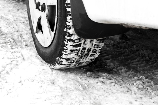 Closeup of car tyres on winter road covered with snow