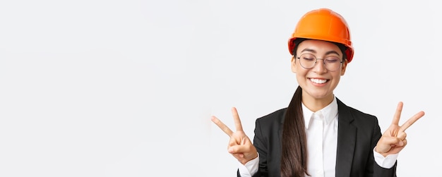 안전 헬멧과 버스에 쾌활한 성공적인 여성 아시아 엔지니어 건설 건축가의 근접 촬영