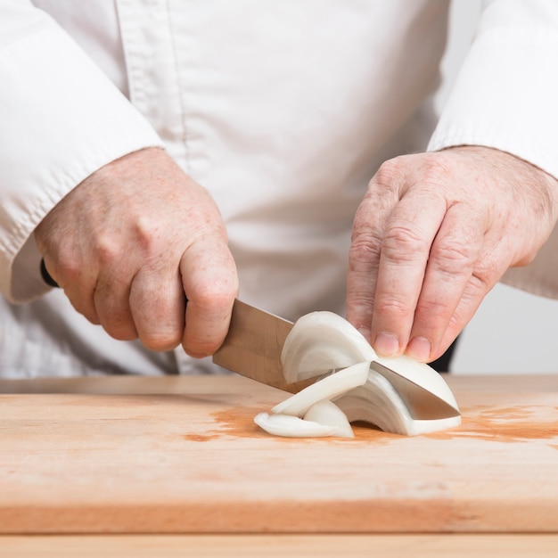 Free photo closeup chef slicing oniono