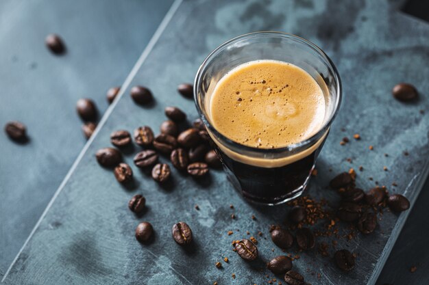 Closeup of classic fresh espresso served on dark surface.