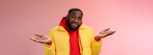 Closeup clueless unaware handsome stylish africanamerican bearded man in yellow jacket shrugging han